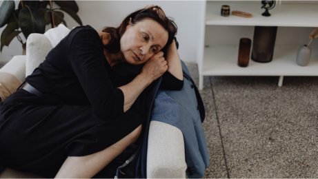 Zamyšlená žena ležící na pohovce – zranitelnost a obava z blízkosti