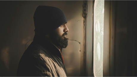 Zamyšlený muž u okna při hledání psychické diagnózy