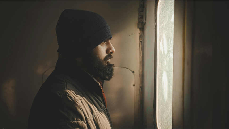 Zamyšlený muž u okna při hledání psychické diagnózy